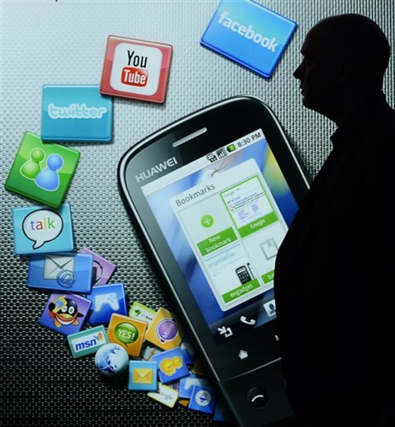 In this Feb. 17, 2010 file photo, a man walks past a banner at the Mobile World Congress in Barcelona, Spain. Silicon Valley is looking like a winner in the tug-of-war with carriers over who's going to control the new world of Internet-connected phones.